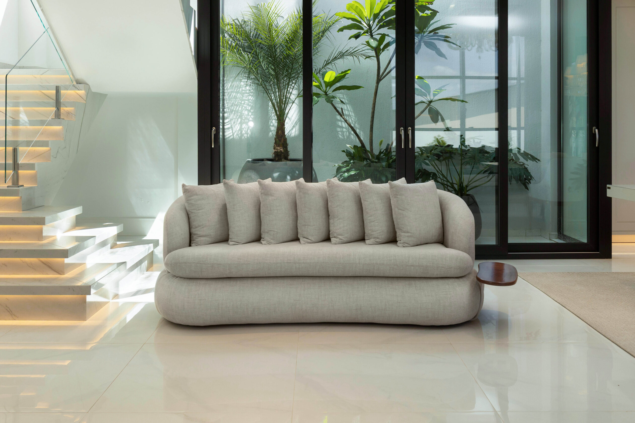 Sofá curvo em ambiente amplo e iluminado - Nuvvo Design