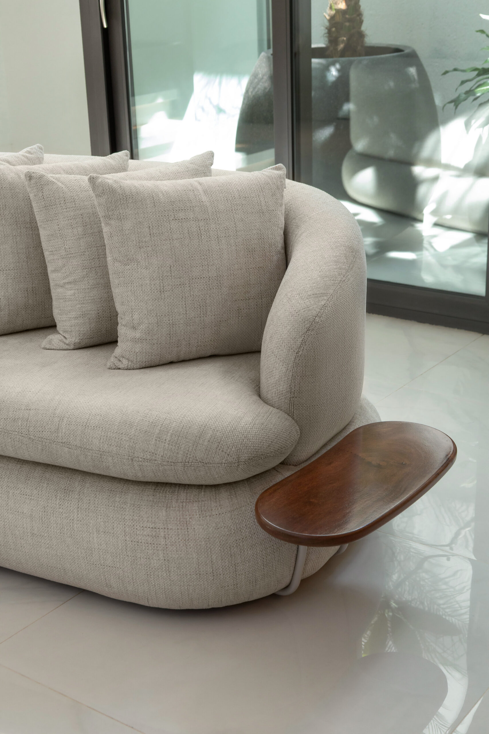 Detalhe de sofá curvo com bandeja de madeira acoplada - Nuvvo Design